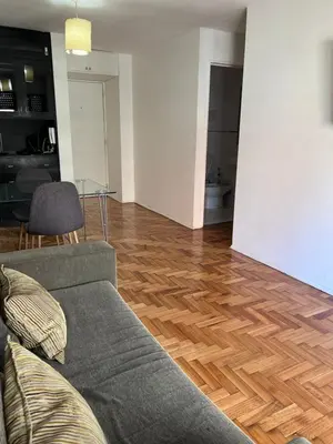 a living room with a couch and a wooden floor at Nueva Córdoba Temporario in Cordoba