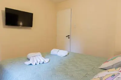 a bedroom with a bed with towels and a flat screen tv at Nueva Córdoba Temporario in Cordoba