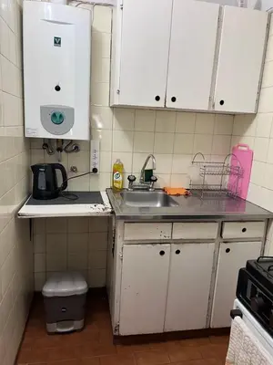 a small kitchen with white cabinets and a sink at Nueva Córdoba Temporario in Cordoba