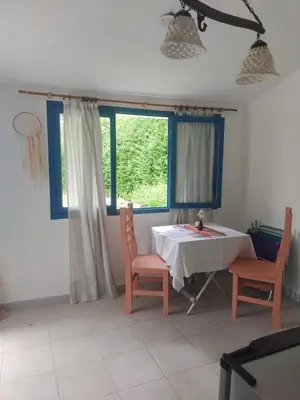 a dining room with a table and chairs and a window at La Calma, casa de Rio in Los Reartes
