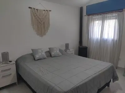 a bedroom with a large bed and a window at La Calma, casa de Rio in Los Reartes