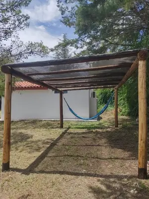 a wooden pavilion with a hammock under it at La Calma, casa de Rio in Los Reartes