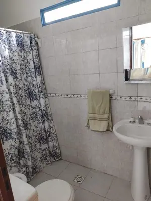 a bathroom with a shower curtain and a sink at La Calma, casa de Rio in Los Reartes
