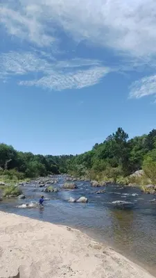 a person standing in the water near a river at La Calma, casa de Rio in Los Reartes