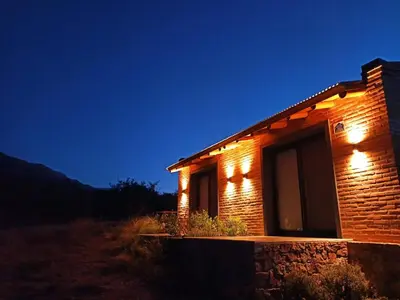 a brick house with lights on it at night at Tintitacos in Los Hornillos
