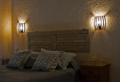 a bedroom with a bed with two lights on the wall at Tintitacos in Los Hornillos