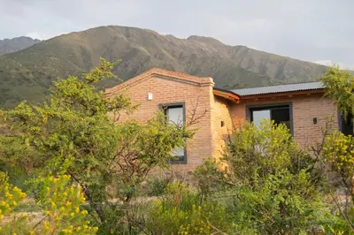 a brick house with mountains in the background at Tintitacos in Los Hornillos