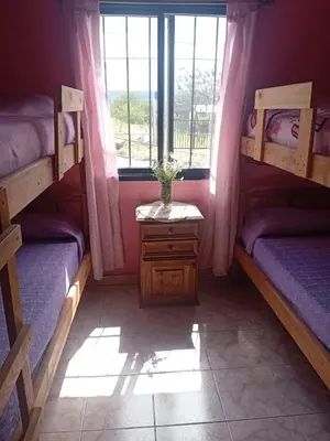 a room with two bunk beds and a window at La casita Tanti in Tanti Nuevo