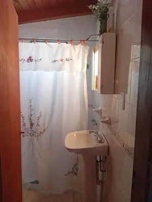a bathroom with a sink and a shower curtain at La casita Tanti in Tanti Nuevo