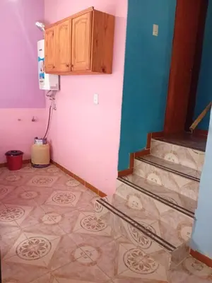 a room with stairs and a cabinet and a tile floor at La casita Tanti in Tanti Nuevo