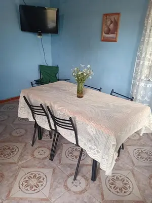 a dining room table with a vase of flowers on it at La casita Tanti in Tanti Nuevo