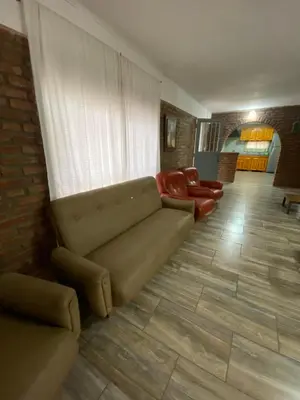 a living room with a couch and red chairs at Casa en complejo con pileta compartida in San Roque