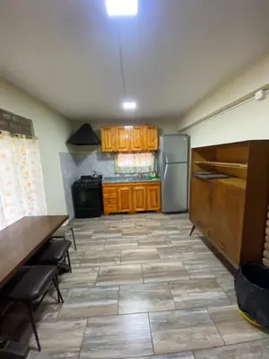 a kitchen with wooden cabinets and a refrigerator at Casa en complejo con pileta compartida in San Roque