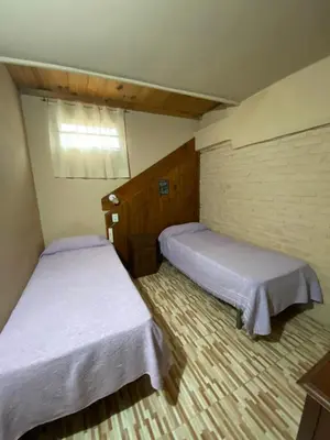 two beds in a small room withermottermott at Casa en complejo con pileta compartida in San Roque
