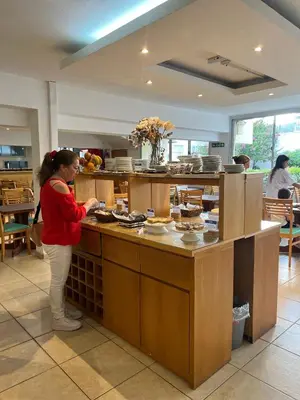 a woman standing in a kitchen preparing food at Gran Lourdes Hotel in Villa Carlos Paz