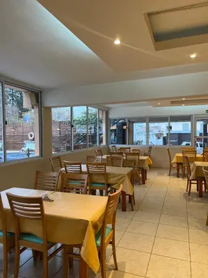 a restaurant with tables and chairs and windows at Gran Lourdes Hotel in Villa Carlos Paz