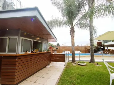 a resort with a bar next to a pool at Gran Lourdes Hotel in Villa Carlos Paz