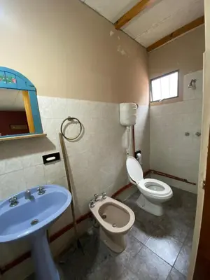 a bathroom with a toilet and a sink at Departamento con pileta compartida en complejo in San Roque