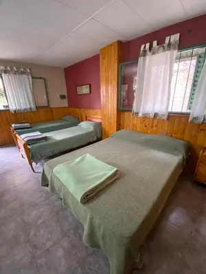 a room with three beds in a room at Departamento con pileta compartida en complejo in San Roque
