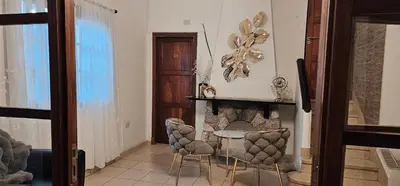 a living room with a table and chairs and a fireplace at Casona Boutique Córdoba-Habitaciones privadas in Cordoba