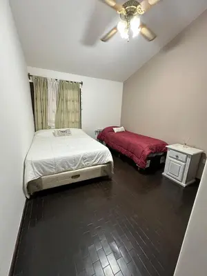 a small bedroom with two beds and a table at Casa del Centro in Santa Rosa de Calamuchita