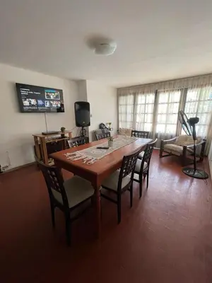 a living room with a wooden table and chairs at Casa del Centro in Santa Rosa de Calamuchita