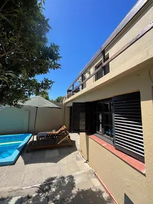 a house with a swimming pool and an umbrella at Casa del Centro in Santa Rosa de Calamuchita