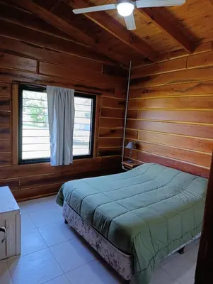 a bedroom with a bed in a wooden cabin at CabañaReartes in Los Reartes