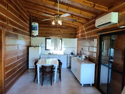 a kitchen with wooden walls and a table and a ceiling at CabañaReartes in Los Reartes