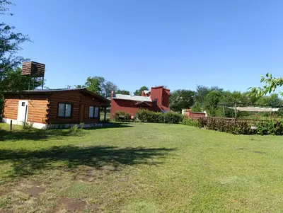 a large yard in front of a log cabin at CabañaReartes in Los Reartes
