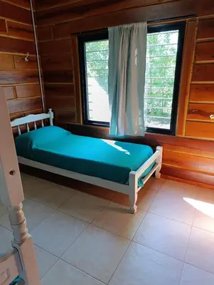a bed sitting in a room with a window at CabañaReartes in Los Reartes