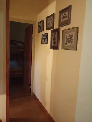 a hallway with framed pictures on a wall at Casa Los Naranjos in La Paz