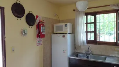 a kitchen with a refrigerator and a microwave on the wall at Casa Los Naranjos in La Paz