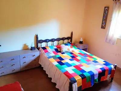 a bedroom with a bed with a colorful quilt on it at Casa Los Naranjos in La Paz