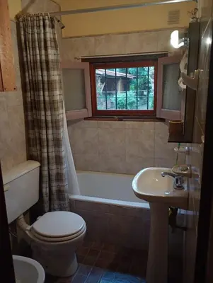 a bathroom with a tub and a toilet and a sink at Casa Los Naranjos in La Paz