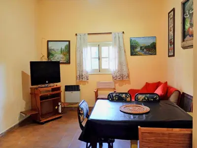 a living room with a table and a television at Casa Los Naranjos in La Paz