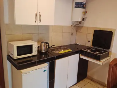 a small kitchen with a microwave and a stove at Depto Calamuchita Rumipal in Villa Rumipal