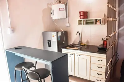 a small kitchen with a counter and chairs in it at Monoambiente 3 personas in Río Segundo
