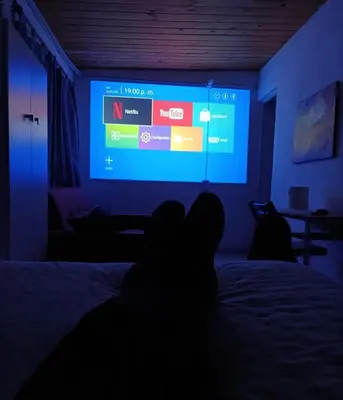 a person laying on a bed in front of a screen at Monoambiente 3 personas in Río Segundo