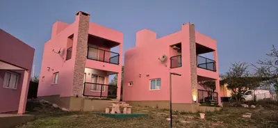 a pink building with a picnic table in front of it at Las liebres in San Lorenzo