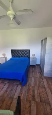 a bedroom with a blue bed and a wooden floor at Las liebres in San Lorenzo