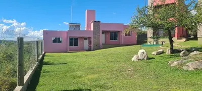 a pink house with a fence and a yard at Las liebres in San Lorenzo