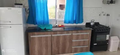 a kitchen with blue curtains and a sink and a refrigerator at Las liebres in San Lorenzo