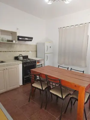 a kitchen with a wooden table and four chairs at Casas Los Nogales in Arroyo de Los Patos