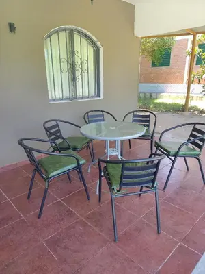 a table and chairs sitting around a table and chairs at Casas Los Nogales in Arroyo de Los Patos
