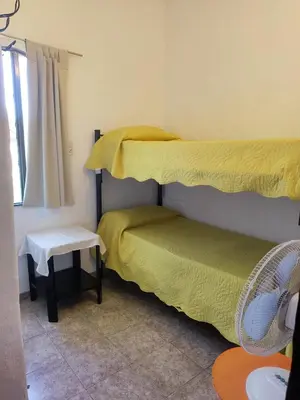 a small room with two beds and a window at Casas Los Nogales in Arroyo de Los Patos