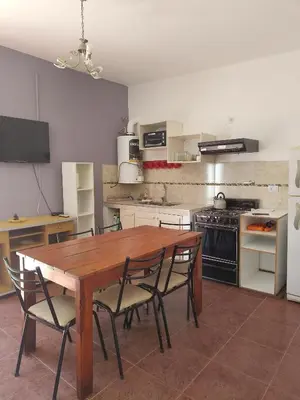 a kitchen with a wooden table and chairs in it at Casas Los Nogales in Arroyo de Los Patos