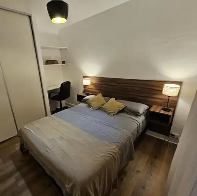 a bedroom with a bed and two lamps and a chair at Departamento en B Gral Paz, a metros de Hospital Italiano in Cordoba