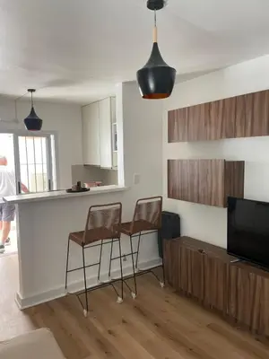 a kitchen with two chairs and a bar in a room at Departamento en B Gral Paz, a metros de Hospital Italiano in Cordoba