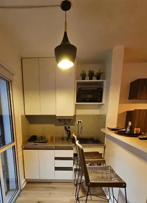 a kitchen with white cabinets and a pendant light at Departamento en B Gral Paz, a metros de Hospital Italiano in Cordoba